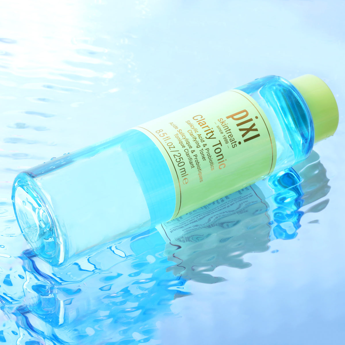 Pixi Clarity Tonic bottle on a blue water background